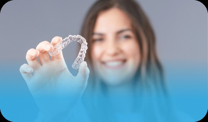 Woman holding Invisalign type clear aligners