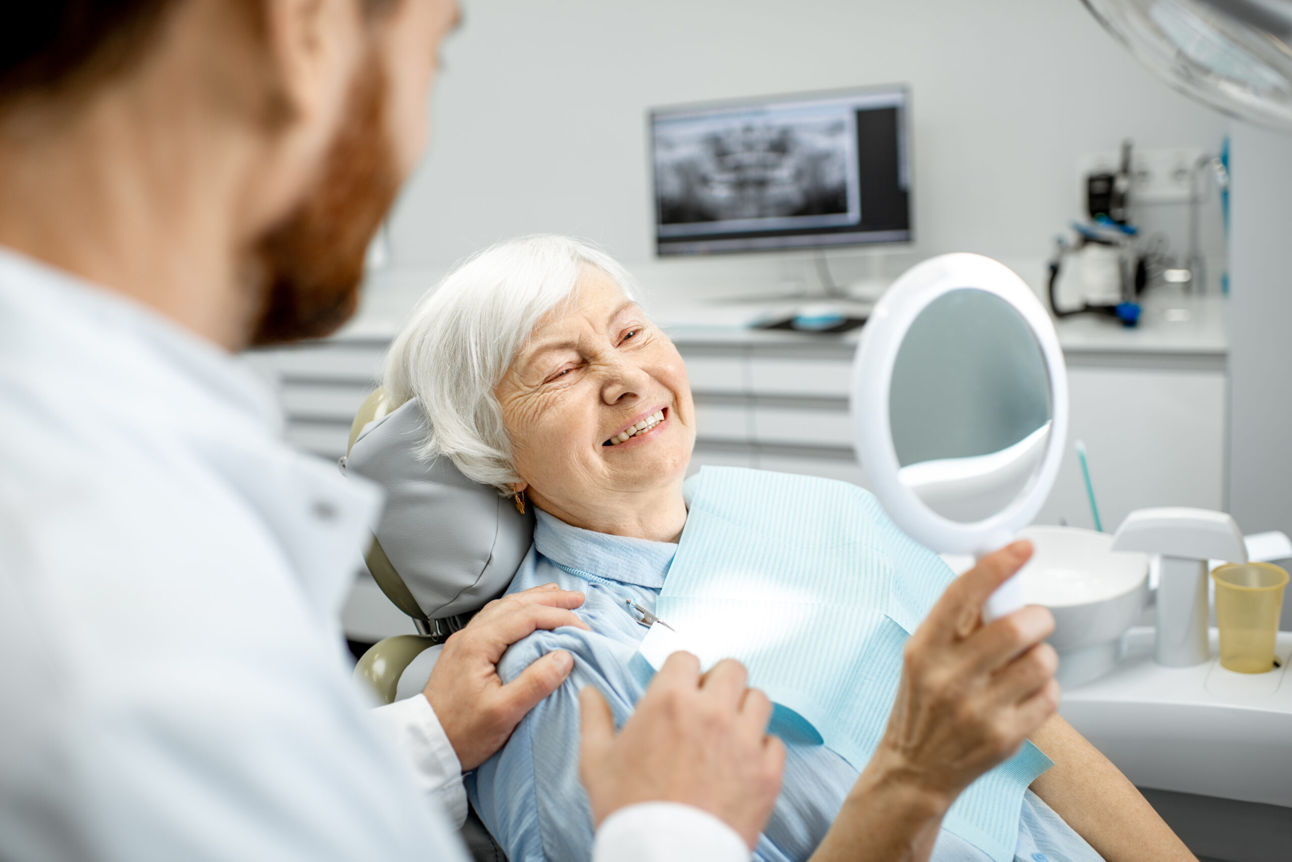 Anciana disfrutando de su sonrisa en la consulta del dentista