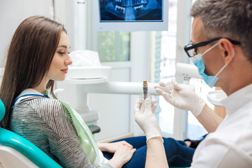 Un dentista mostrando a su paciente un implante dental