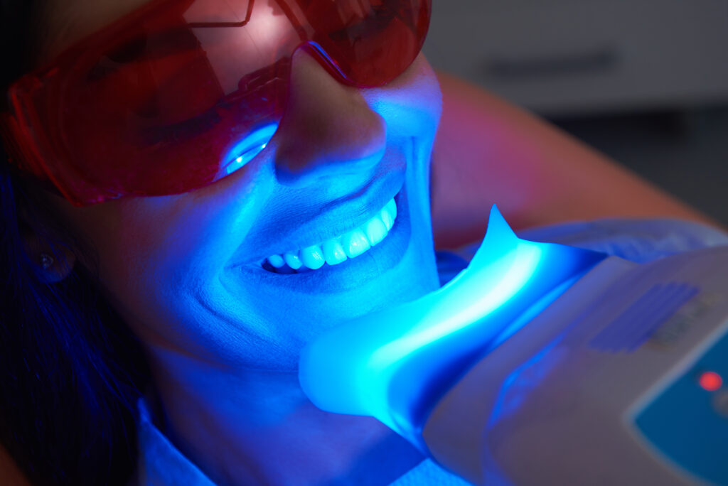 Primer plano de señora feliz haciendo tratamiento dental en clínica dental